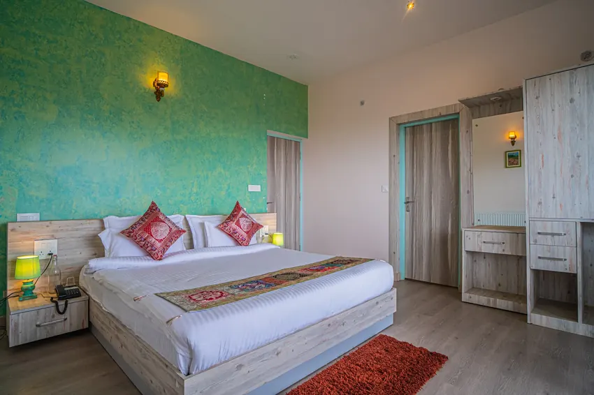 Master suite with wooden ceiling, artwork, and plush bed at Adrushya Estates