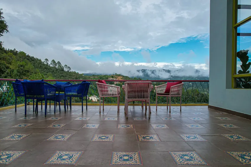 Sun setting behind distant hills casting warm glow over Adrushya Estates Mukteshwar