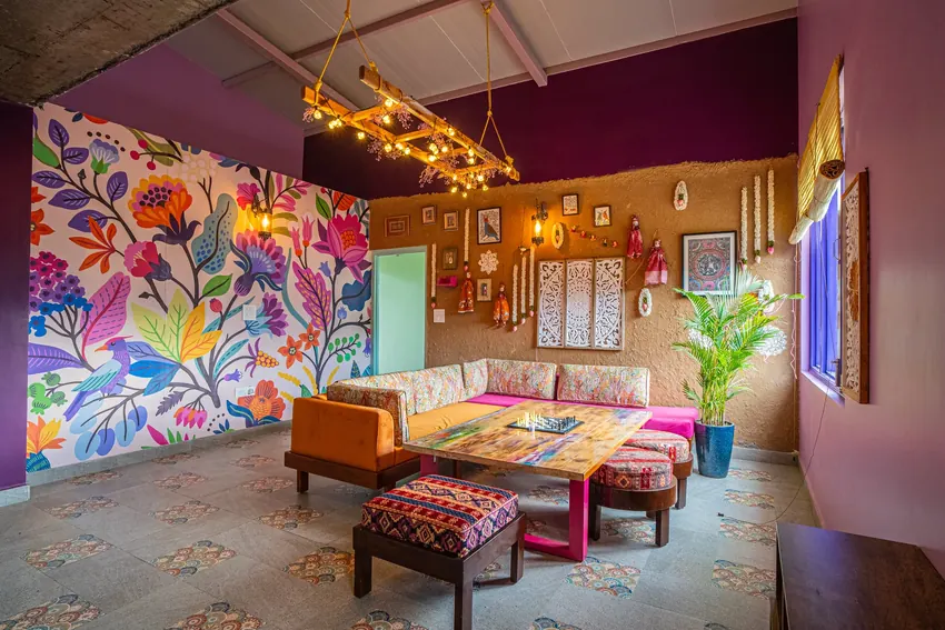 Lounge room with plush sofas, art paintings, and mountain decor at Adrushya Estates